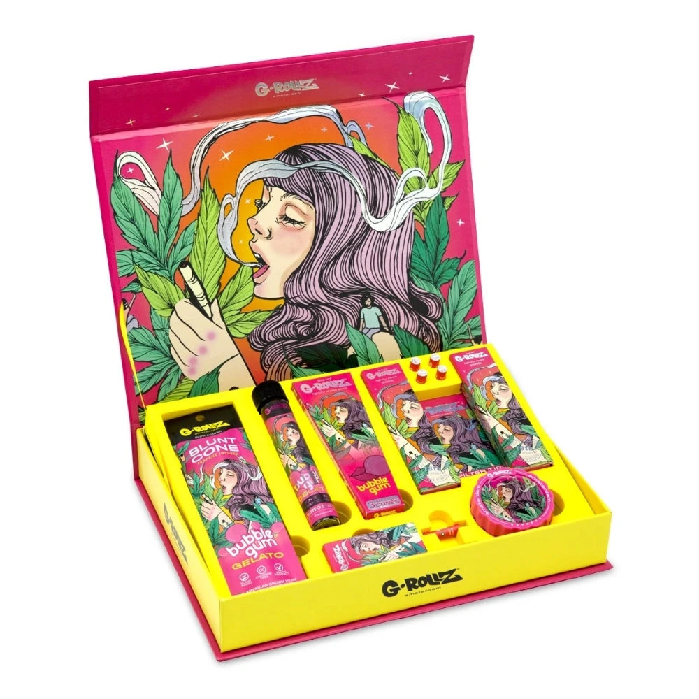G-ROLLZ Gift Box Colossal Dream S, geöffnete pink-gelbe Geschenkbox mit Illustrations-Motiv und arrangiertem Set-Inhalt aus Cones, Papers, Tips, Box und Grinder